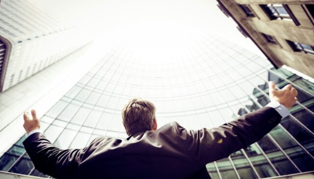 low-angle photography of man in the middle of buidligns
