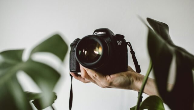 person holding Canon EOS DSLR camera